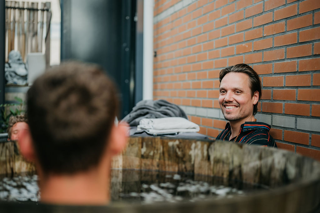 Chris Rauwendaal die kijkt naar een deelnemer van een ijsbad workshop – krachtige ervaring van koude training, ademhaling en mentale veerkracht.