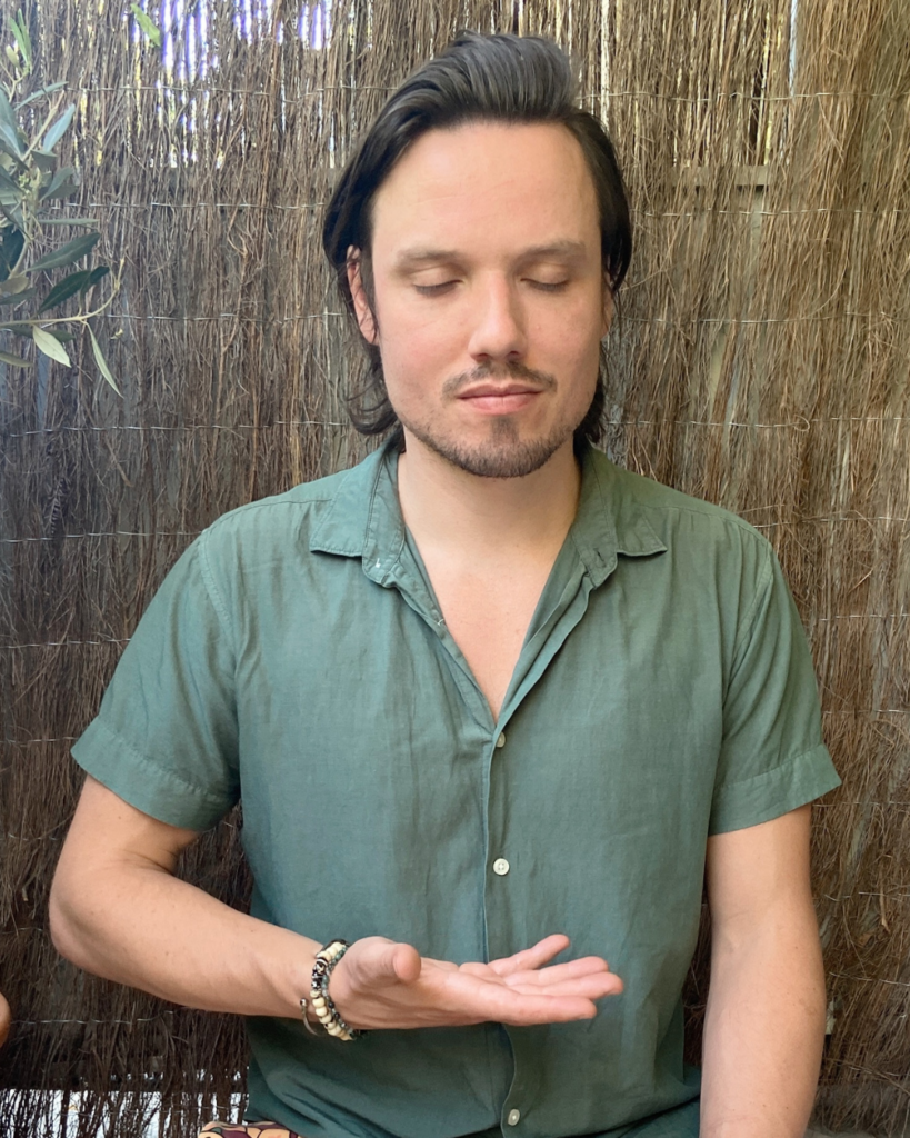 Chris Rauwendaal met zijn hand op het middenrif – focus op buikademhaling en het activeren van de middenrifspieren voor rust en herstel.